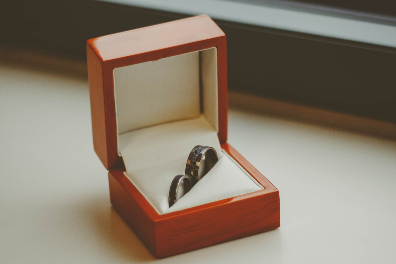 two wedding bands in a wooden jewelry box
